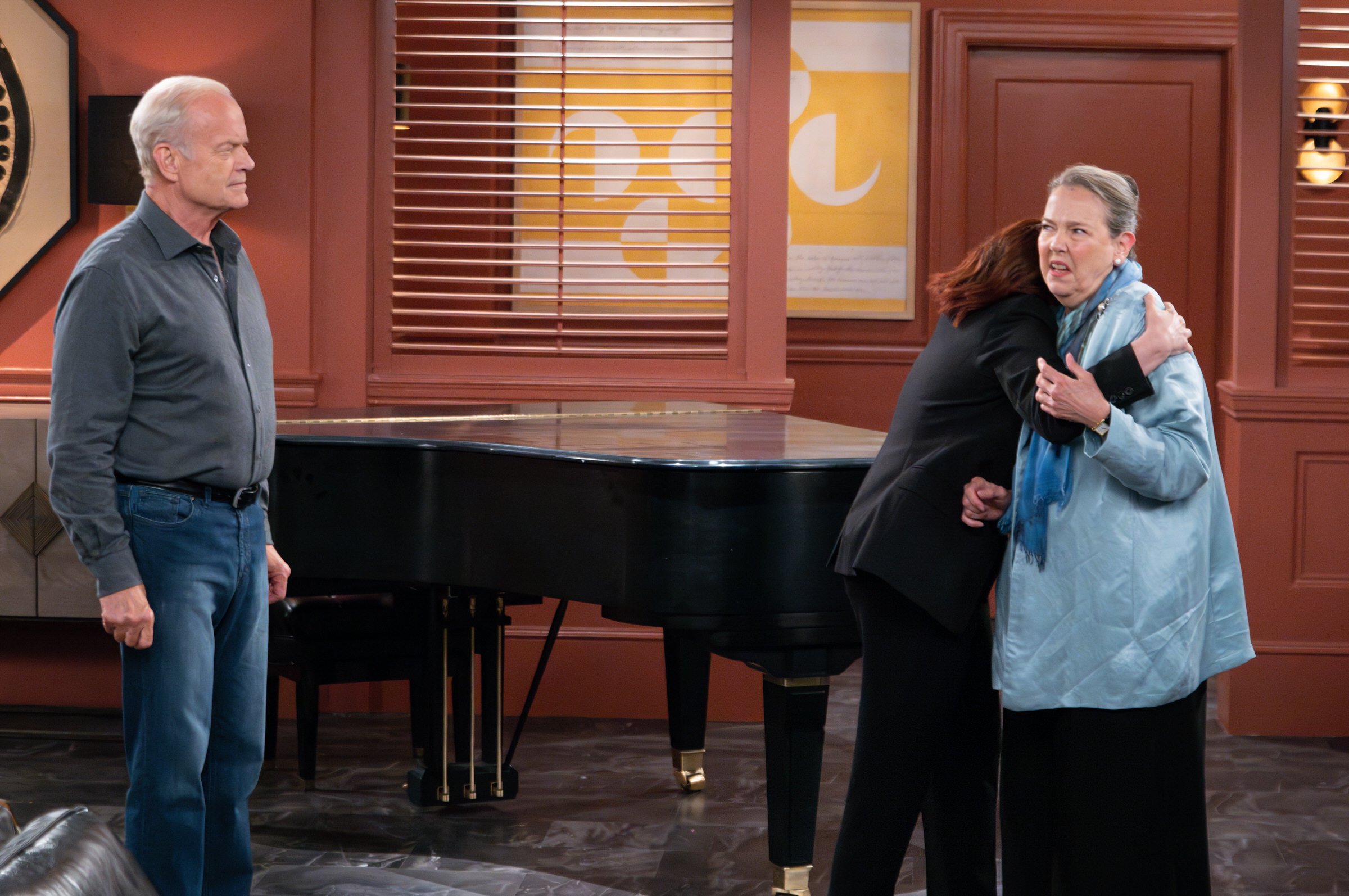 Harriet Sansom Harris and Kelsey Grammer stand near a piano in the Frasier revival